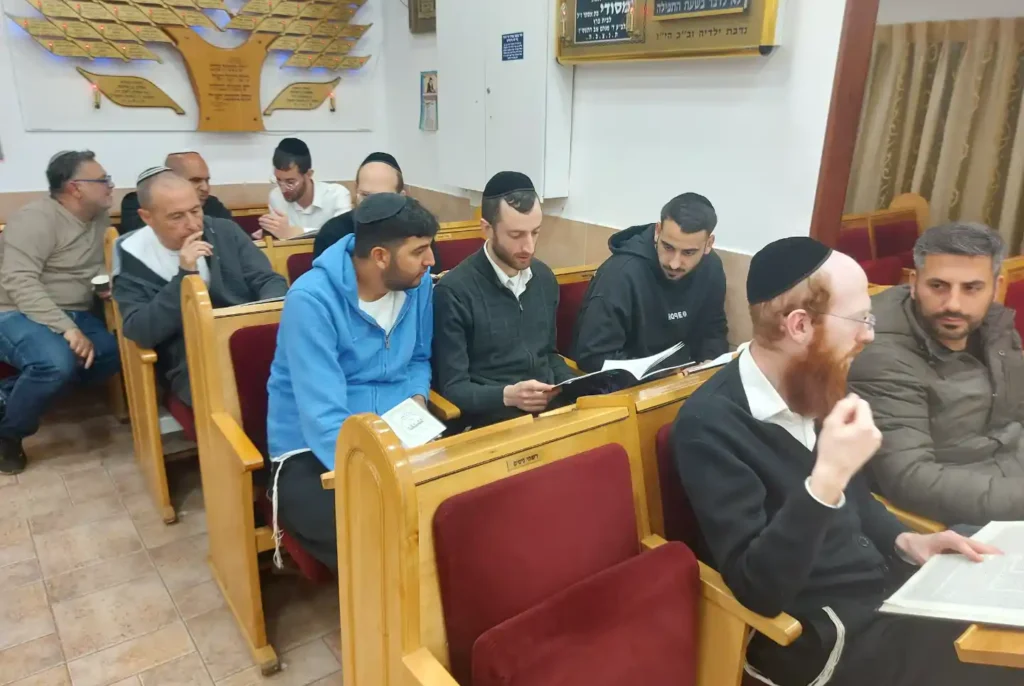 אנשים לומדים יחד תורה בחברותא בבית המדרש